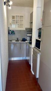 アルジェレス・シュル・メールにあるIdyllique ! Terrasse vue jardin et montagne, parking, local à vélos, à 2 pas de la plage et piscine de mai à septembre !の赤いタイルフロアのキッチン(白いキャビネット付)