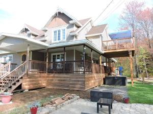 a house with a large deck on the front of it at Gite Passion et Tendresse B&B in Shefford