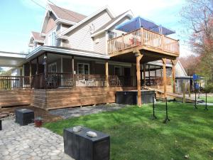 a house with a large deck on the lawn at Gite Passion et Tendresse B&B in Shefford