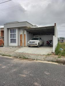 a white car parked in front of a house at Casa com piscina aquecida e área de festas no litoral in Ilhota