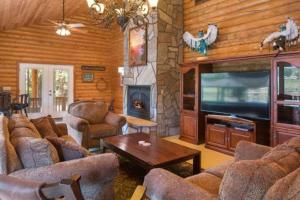 ein Wohnzimmer mit Sofas, Fernseher und Kamin in der Unterkunft Quarter Horse Lodge Grand Southwest Cabin Sleeps 16 Amazing Views Near Grand Canyon in Williams