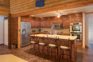 eine Küche mit einer Mittelinsel mit Barhockern in der Unterkunft Quarter Horse Lodge Grand Southwest Cabin Sleeps 16 Amazing Views Near Grand Canyon in Williams