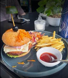 a plate with a sandwich and french fries and ketchup at Sinharaja Eliphinity Hotel and Restaurant in Nikawatawana
