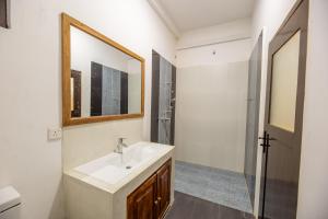 Un baño con lavabo, espejo y ducha. en Merenza, en Unawatuna