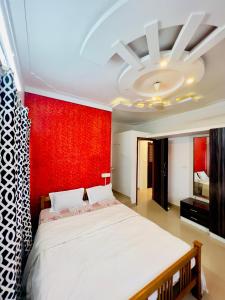 a bedroom with a large bed with a red wall at KK Residences in Madikeri +19 photos