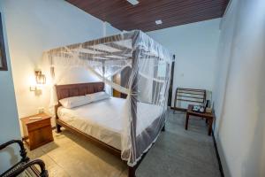 un dormitorio con una cama con dosel en Merenza, en Unawatuna