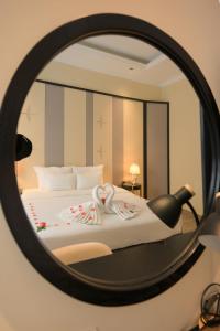 un espejo que refleja una cama con bastones de caramelo encima en San Hotel & Pool, en Hanói