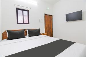 コルカタにあるHOTEL O SPのベッドルーム(白い大型ベッド1台、薄型テレビ付)