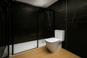 a bathroom with a toilet and a shower at Apartamentos La Gringa Centro Gijon II Obra nueva con posibilidad de Parking in Gijón +14 photos