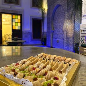 een hoop eten op een tafel in een kamer bij Riad Dar El bellar in Fès