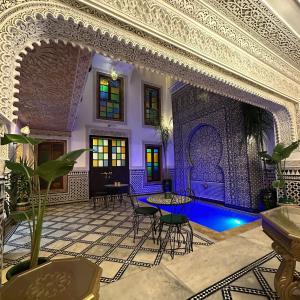een woonkamer met een zwembad in een huis bij Riad Dar El bellar in Fès