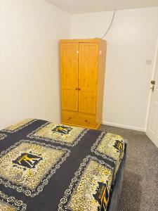 a bedroom with a bed and a wooden cabinet at Goodness homes in Manchester