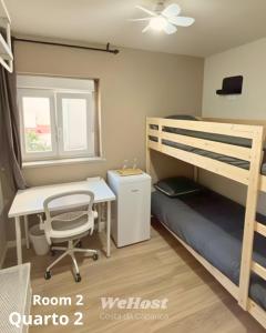 a bedroom with a bunk bed with a desk and a desk at We host in Costa da Caparica