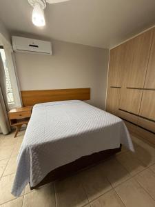 a bedroom with a bed with a white bedspread at Entre o Mar e o Centro - A melhor Localização in Torres