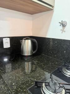 a tea kettle sitting on top of a stove in a kitchen at Entre o Mar e o Centro - A melhor Localização in Torres +4 photos