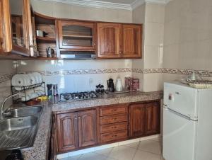 una cucina con mobili in legno e un frigorifero bianco di Luxury Apartment in Fes City Centre for Families a Fes