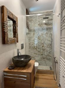 ein Badezimmer mit Waschbecken und Glasdusche in der Unterkunft Cjasa Celeste - Apartments in Andreis in Andreis