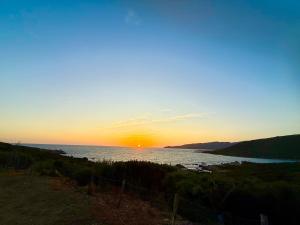 a sunset over a body of water with the sun setting at Charmant Studio dans dépendance face à la mer in Serra-di-Ferro