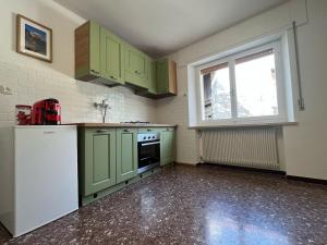 eine leere Küche mit grünen Schränken und einem Fenster in der Unterkunft Cjasa Celeste - Apartments in Andreis in Andreis + 26 Fotos