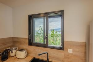 a kitchen with a window over a counter with a sink at Charmant Studio dans dépendance face à la mer in Serra-di-Ferro