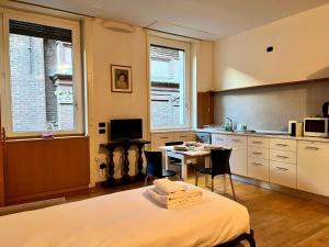 a room with a bed and a kitchen with a table at Kibilù - Cozy Studio few steps from Duomo City Centre in Milan