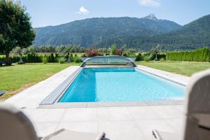 a swimming pool in a yard with mountains in the background at Nico's Place in Jenig
