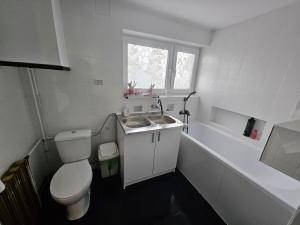 a white bathroom with a toilet and a sink at Apartament 3 in Biała Podlaska