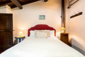 une chambre avec un grand lit blanc et deux lampes dans l'établissement Nature Retreat In Garfagnana, à San Romano