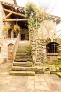 - un bâtiment en pierre avec des escaliers menant à une porte dans l'établissement Nature Retreat In Garfagnana, à San Romano 14 autres photos