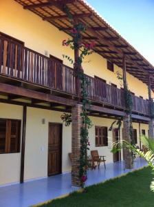 a house with a balcony with flowers on it at Pousada Brisa Do Pontal in Fortim