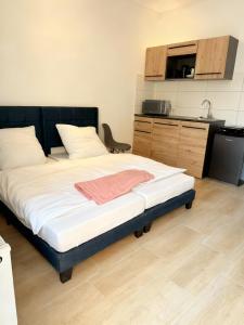 バート・エーンハウゼンにあるLoft am Kurpark, nähe Kurpark, GOP, Balitherme, mit Waschmaschine u Kücheのキッチン付きの客室の大型ベッド1台分です。