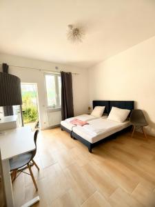 バート・エーンハウゼンにあるLoft am Kurpark, nähe Kurpark, GOP, Balitherme, mit Waschmaschine u Kücheのベッドと机が置かれた寝室