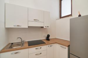 a kitchen with white cabinets and a sink and a refrigerator at AM10 - Modern flat in historic center in Perugia +14 photos