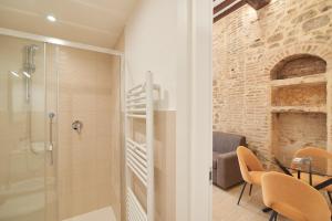 a bathroom with a shower and a table with chairs at AM10 - Modern flat in historic center in Perugia