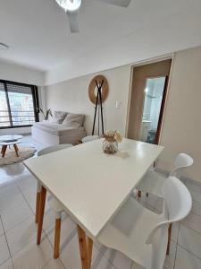 a white dining table and chairs in a living room at Departamento Bloom in Bahía Blanca