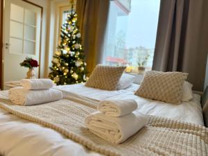 a bedroom with two beds with towels and a christmas tree at Adorable Arctic Apartments - Private Sauna & Free Parking in Rovaniemi