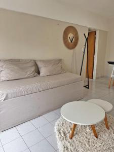 a living room with a bed and a white table at Departamento Bloom in Bahía Blanca +4 photos