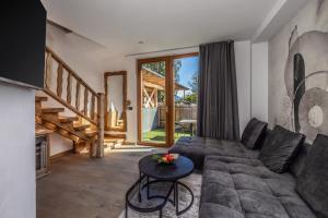 ヴェルミーリオにあるHotel Chalet Al Foss - Adults Onlyのソファとテーブルのあるリビングルーム