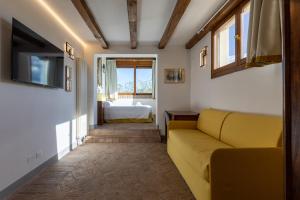 uma sala de estar com um sofá amarelo e uma cama em BolognaRoomscom - B and B La Cascina em Sasso Marconi