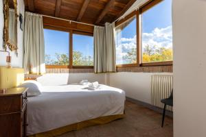 um quarto com uma cama grande e janelas grandes em BolognaRoomscom - B and B La Cascina em Sasso Marconi mais 69 fotografias