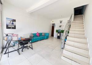 ein Wohnzimmer mit einem blauen Sofa und einer Treppe in der Unterkunft Hotel 7 in Cúcuta