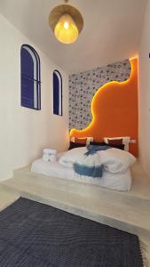 a bedroom with a large bed with an orange headboard at Riad Lyabaïana privatisé, piscine et vue mer dans la médina in Tangier