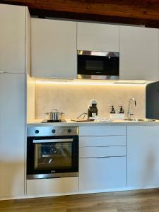 a white kitchen with a stove and a sink at casa duomo vicenza in Vicenza