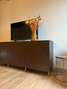 a large brown cabinet with a television on top of it at casa duomo vicenza in Vicenza