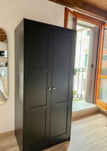 a black cabinet in a room with a window at casa duomo vicenza in Vicenza
