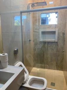 a bathroom with a toilet and a glass shower at Hotel Bonanzza Coxim in Coxim +48 photos