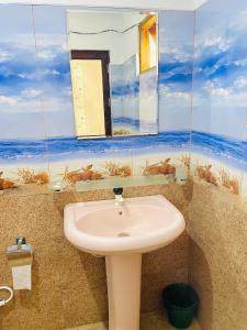 a bathroom with a sink and a mirror at Racy Nature Cottage in Ella
