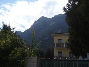 a house with a fence and mountains in the background at Riva Apartment Negrelli in Riva del Garda