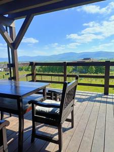 a table and bench on a wooden deck with a view at Domek w górach Łubinowa 6 in Międzylesie
