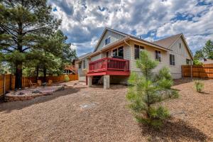 a house with a red deck on a yard at Pine Mountain Trail Pool Table Dog Family Fun in Flagstaff in Flagstaff